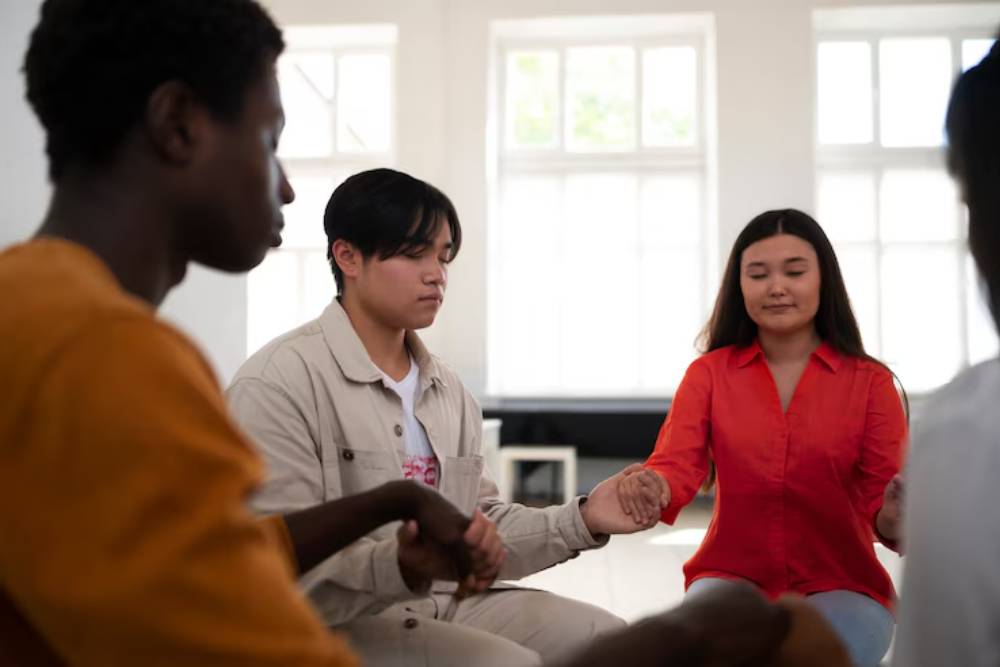 Individuals in Alcohol Rehab in Columbus Ohio join hands in a peaceful group session focused on mindfulness and emotional healing.