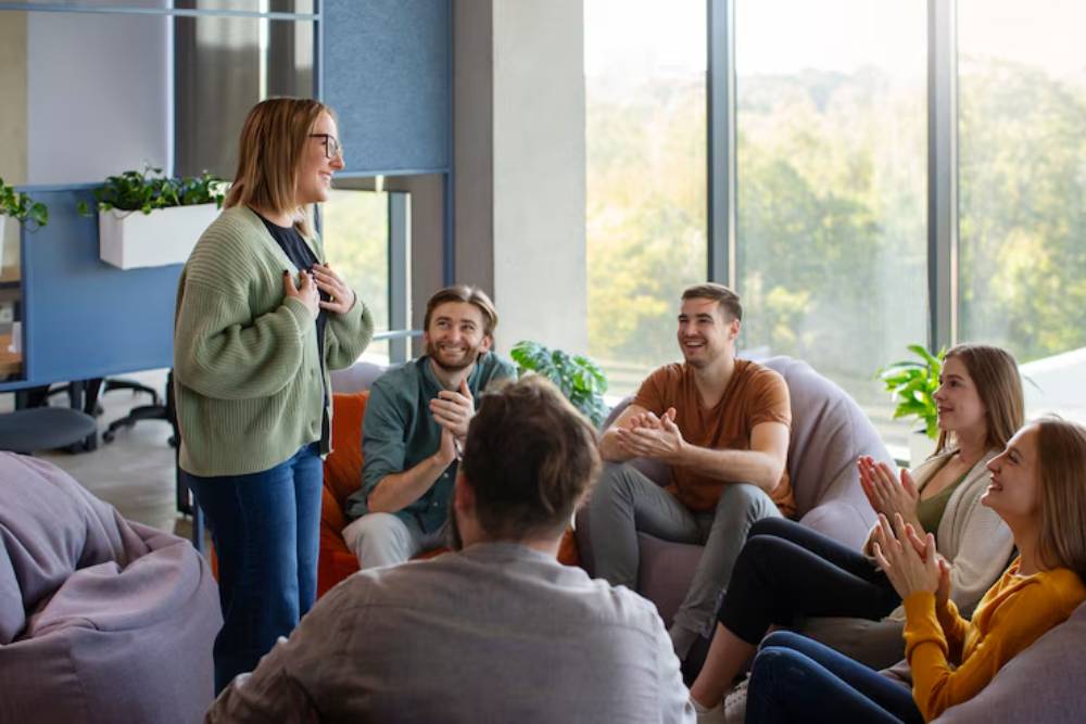 A woman shares her recovery story during a therapy meeting in an intensive outpatient program Columbus Ohio, with others showing support and encouragement.