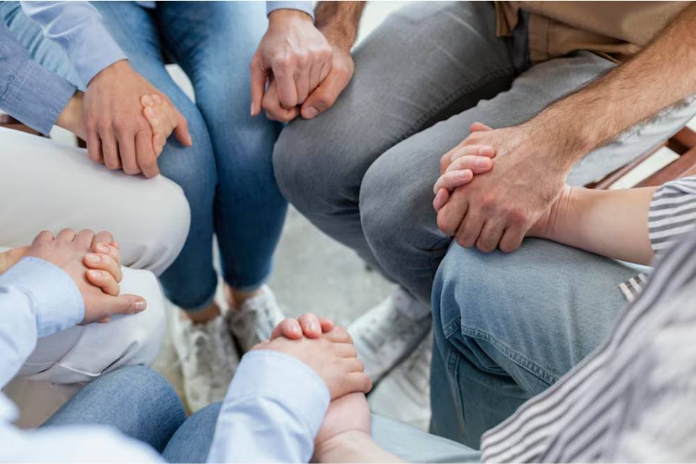 A support group holding hands in a circle, symbolizing community-based cocaine addiction treatment in Columbus OH.