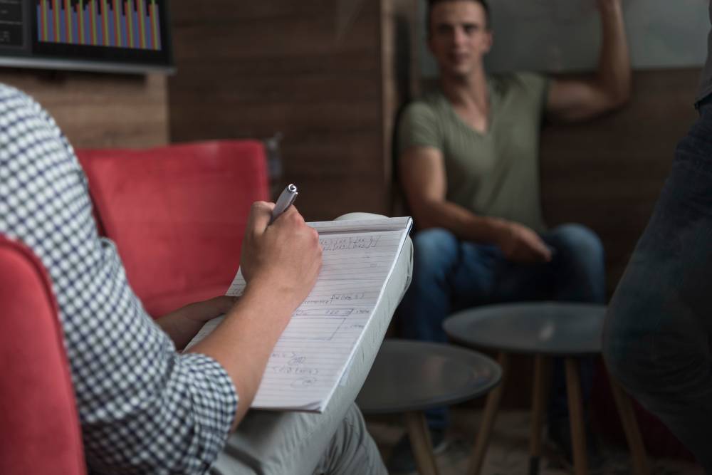 A counselor taking notes during a recovery session, highlighting personalized care in Meth Addiction Treatment in Columbus OH.